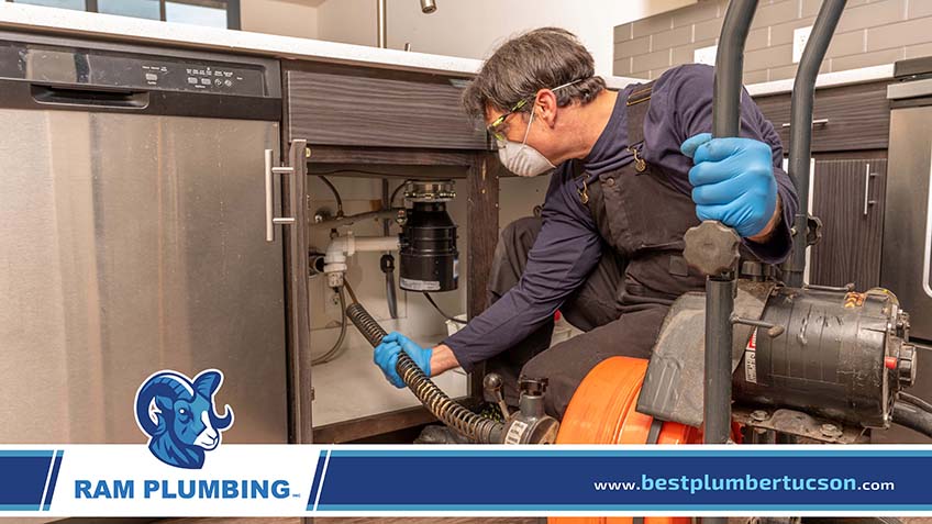 A Plumber Conducting Drain Cleaning Using an Auger