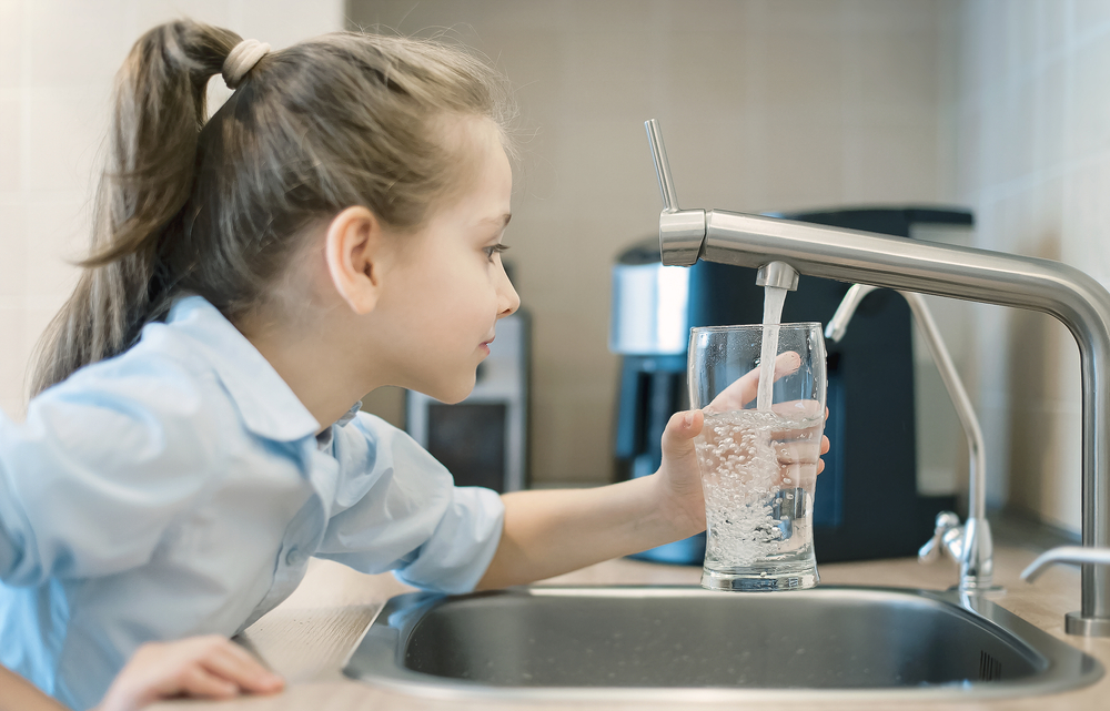drinking glass being filled with tap water